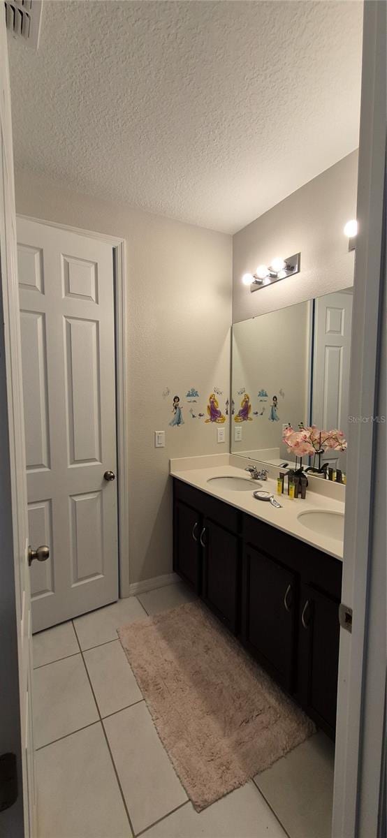 1544 Nassau Point Trl, Kissimmee, FL 34747 - full bath with double vanity, a textured ceiling, and tile patterned floors