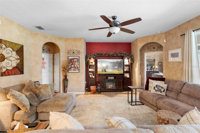 3551 Statham Dr, Apopka, FL 32712 - living room with arched walkways, ceiling fan, baseboards, and a textured ceiling