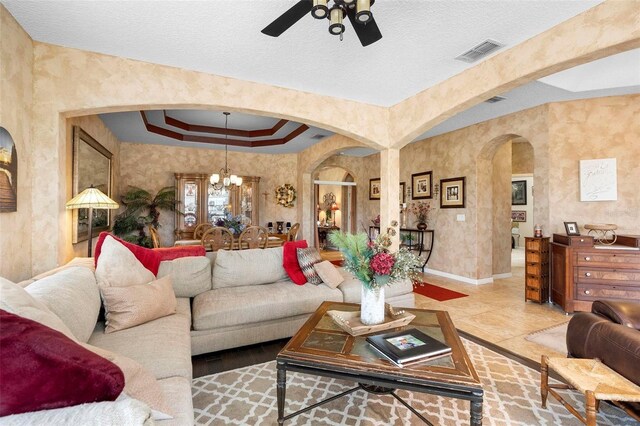 3551 Statham Dr, Apopka, FL 32712 - tiled living room with arched walkways, a chandelier, ceiling fan, baseboards, and a textured ceiling