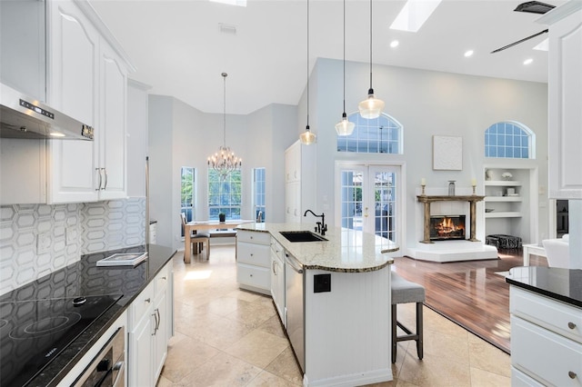 718 Glen Eagle Dr, Winter Springs, FL 32708 - kitchen with wall chimney range hood, a chandelier, a sink, dishwasher, and a skylight