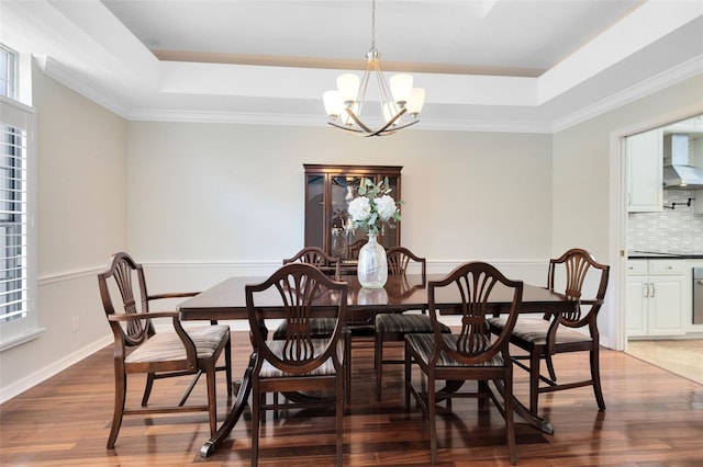 718 Glen Eagle Dr, Winter Springs, FL 32708 - dining room with a tray ceiling, a chandelier, wood finished floors, and ornamental molding