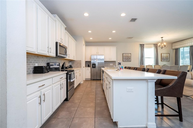 1505 Nassau Point Trl, Kissimmee, FL 34747 - kitchen featuring stainless steel appliances, a sink, a breakfast bar area, backsplash, and a chandelier