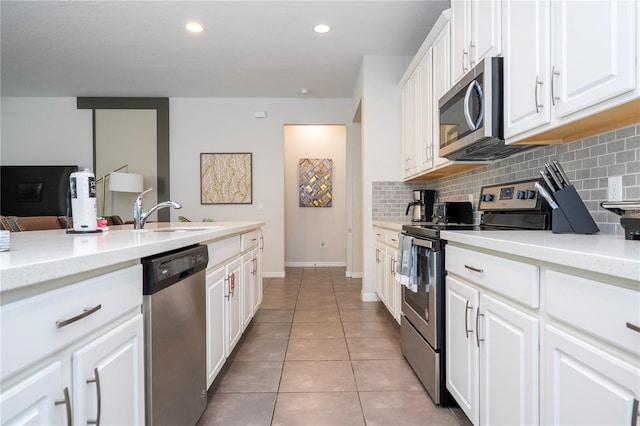 1505 Nassau Point Trl, Kissimmee, FL 34747 - kitchen with stainless steel appliances, tasteful backsplash, light tile patterned floors, white cabinetry, and recessed lighting