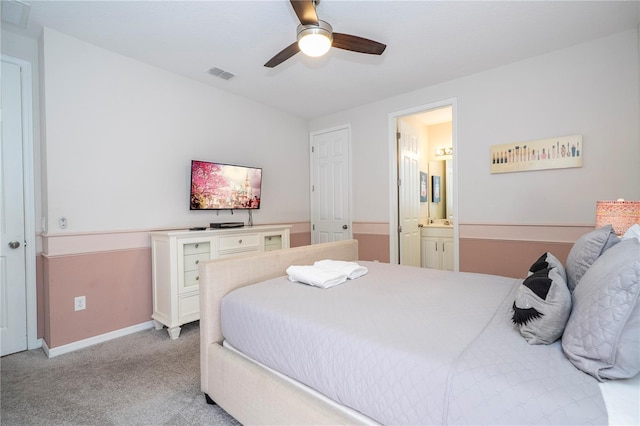 1505 Nassau Point Trl, Kissimmee, FL 34747 - bedroom featuring light colored carpet, ensuite bathroom, baseboards, and ceiling fan
