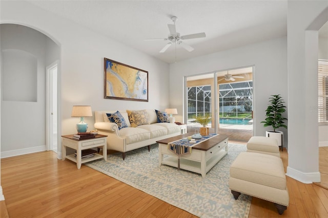 604 Cheviot Ct, Apopka, FL 32712 - living area featuring light wood-style flooring, a ceiling fan, baseboards, and arched walkways