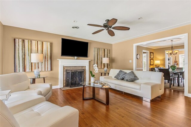 676 Dunblane Dr, Winter Park, FL 32792 - living area featuring a ceiling fan, wood finished floors, a brick fireplace, a chandelier, and baseboards