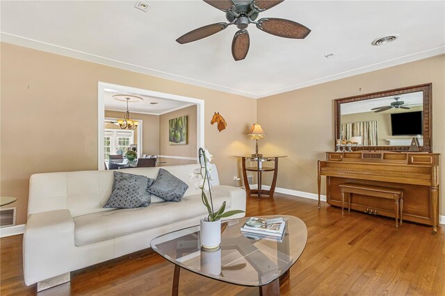676 Dunblane Dr, Winter Park, FL 32792 - living area featuring a ceiling fan, wood finished floors, ornamental molding, baseboards, and a chandelier