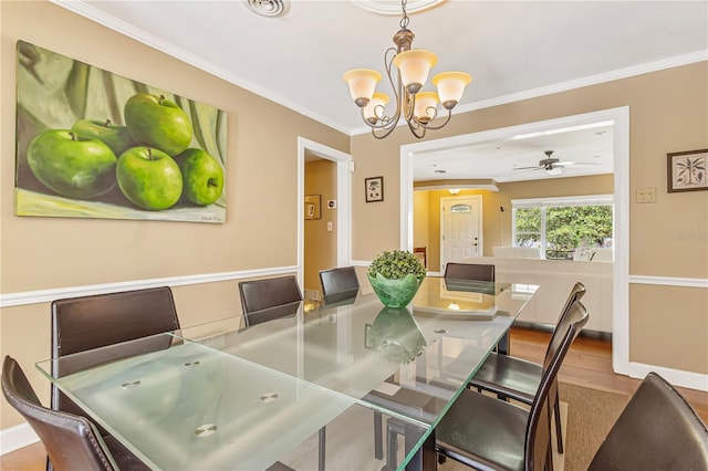 676 Dunblane Dr, Winter Park, FL 32792 - dining space featuring a chandelier, crown molding, a ceiling fan, and wood finished floors