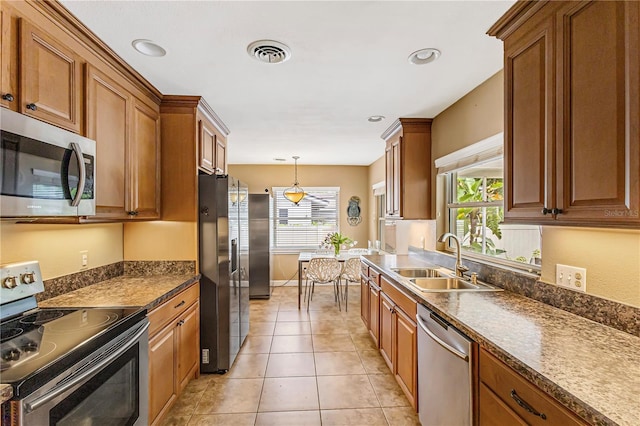 676 Dunblane Dr, Winter Park, FL 32792 - kitchen featuring stainless steel appliances, a sink, brown cabinetry, healthy amount of natural light, and recessed lighting