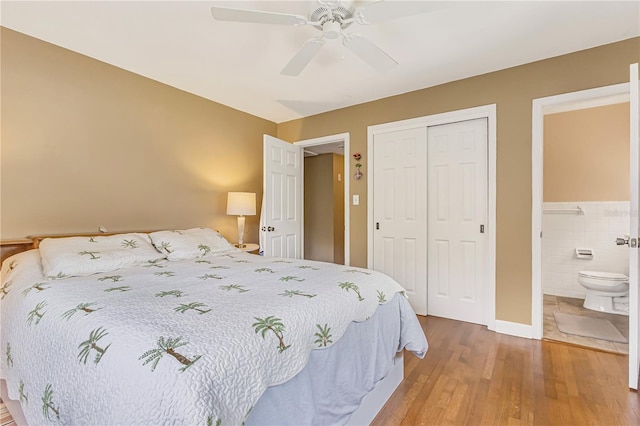 676 Dunblane Dr, Winter Park, FL 32792 - bedroom with a closet, wood finished floors, a ceiling fan, ensuite bathroom, and tile walls