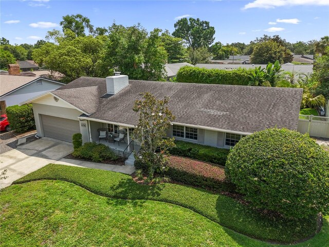 676 Dunblane Dr, Winter Park, FL 32792 - view of front of house with an attached garage, roof with shingles, a chimney, and driveway