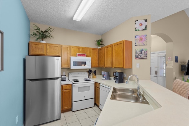8507 Crystal Cove Loop, Kissimmee, FL 34747 - kitchen featuring white appliances, a sink, arched walkways, light countertops, and a textured ceiling