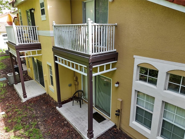 8507 Crystal Cove Loop, Kissimmee, FL 34747 - back of property featuring stucco siding, central air condition unit, and a balcony