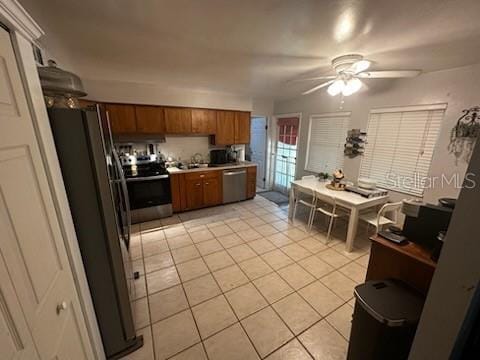 1511 Hobson St, Longwood, FL 32750 - kitchen featuring stainless steel appliances, brown cabinetry, light tile patterned flooring, ceiling fan, and light countertops