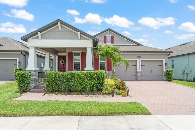 13227 Spring Grove Way, Winter Garden, FL 34787 - craftsman-style home with an attached garage, decorative driveway, covered porch, stone siding, and stucco siding