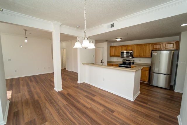 12106 Poppy Field Ln Unit 107, Orlando, FL 32837 - kitchen featuring appliances with stainless steel finishes, a textured ceiling, brown cabinetry, dark wood-type flooring, and light countertops