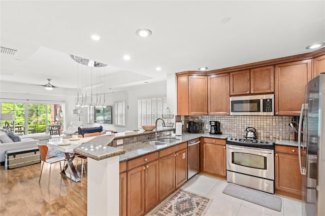7650 Whisper Way Unit 104, Reunion, FL 34747 - kitchen with stainless steel appliances, a sink, open floor plan, light stone counters, and ceiling fan