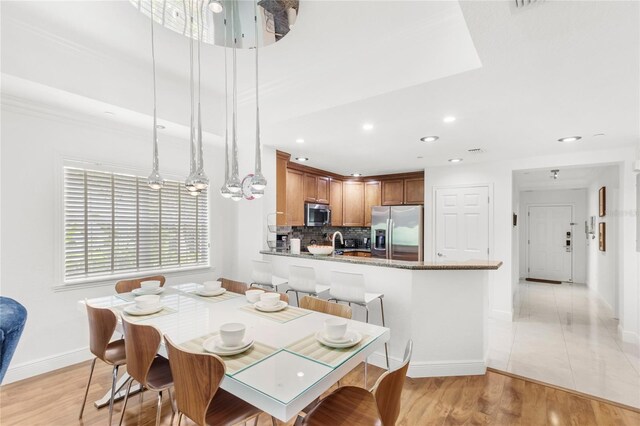 7650 Whisper Way Unit 104, Reunion, FL 34747 - dining space with baseboards, recessed lighting, light wood-style floors, and a chandelier