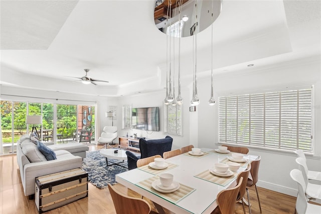 7650 Whisper Way Unit 104, Reunion, FL 34747 - dining room with a raised ceiling, wood finished floors, a ceiling fan, ornamental molding, and baseboards