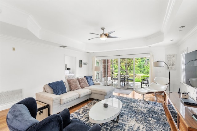 7650 Whisper Way Unit 104, Reunion, FL 34747 - living area featuring a tray ceiling, wood finished floors, ceiling fan, and ornamental molding