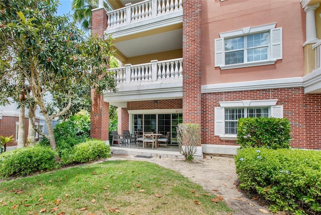 7650 Whisper Way Unit 104, Reunion, FL 34747 - back of property featuring a balcony, brick siding, a patio, and stucco siding