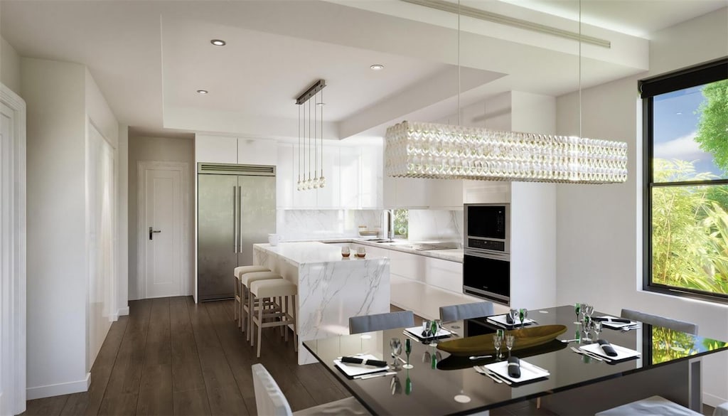 523 W Princeton St Unit 1, Orlando, FL 32804 - kitchen featuring appliances with stainless steel finishes, a tray ceiling, a center island, modern cabinets, and tasteful backsplash