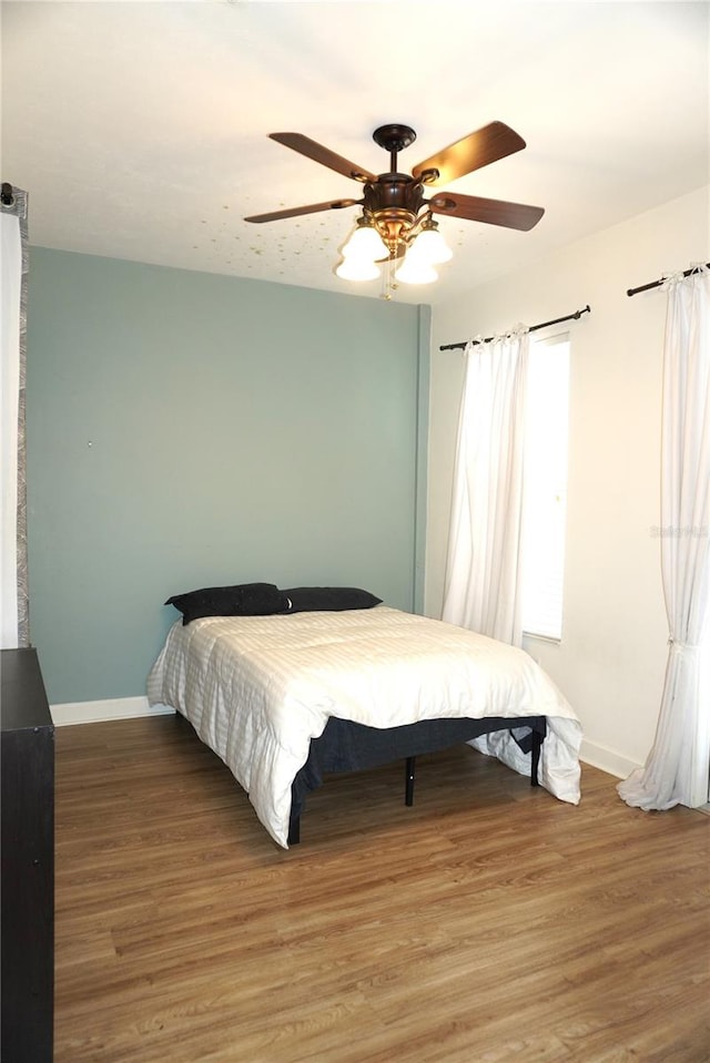 1320 NW 3rd Ave Unit 238, Gainesville, FL 32603 - bedroom featuring baseboards, light wood-style flooring, and ceiling fan