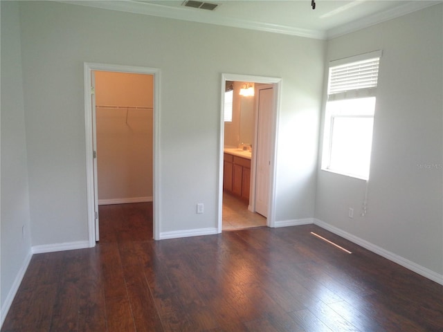 2451 Strandhill St, Orlando, FL 32824 - unfurnished bedroom featuring a walk in closet, crown molding, wood finished floors, a closet, and baseboards
