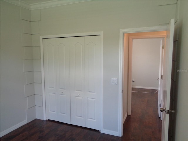 2451 Strandhill St, Orlando, FL 32824 - unfurnished bedroom with dark wood-style flooring, a closet, baseboards, and crown molding