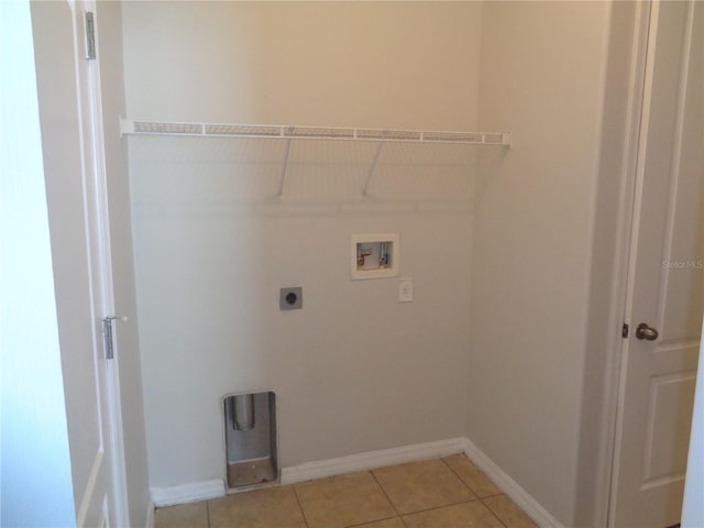 2451 Strandhill St, Orlando, FL 32824 - laundry room with electric dryer hookup, washer hookup, light tile patterned flooring, and baseboards