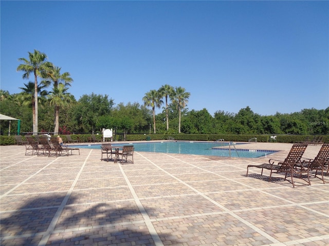 2451 Strandhill St, Orlando, FL 32824 - community pool featuring a patio and view of scattered trees