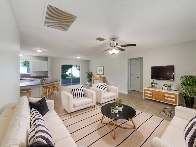 9514 SE 168th Maplesong Ln, The Villages, FL 32162 - living area featuring a ceiling fan, light tile patterned floors, and baseboards