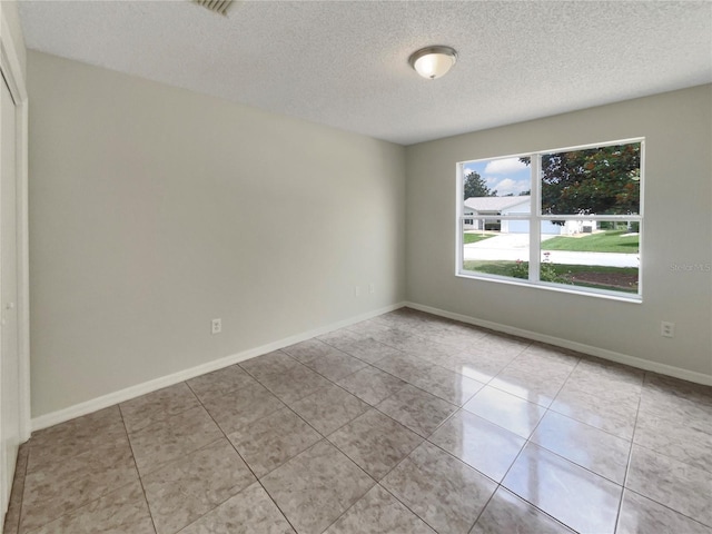 9514 SE 168th Maplesong Ln, The Villages, FL 32162 - unfurnished room featuring a textured ceiling, light tile patterned floors, and baseboards
