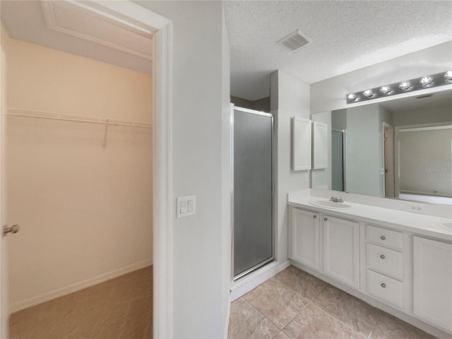 9514 SE 168th Maplesong Ln, The Villages, FL 32162 - full bath featuring a shower stall, a spacious closet, double vanity, a textured ceiling, and baseboards