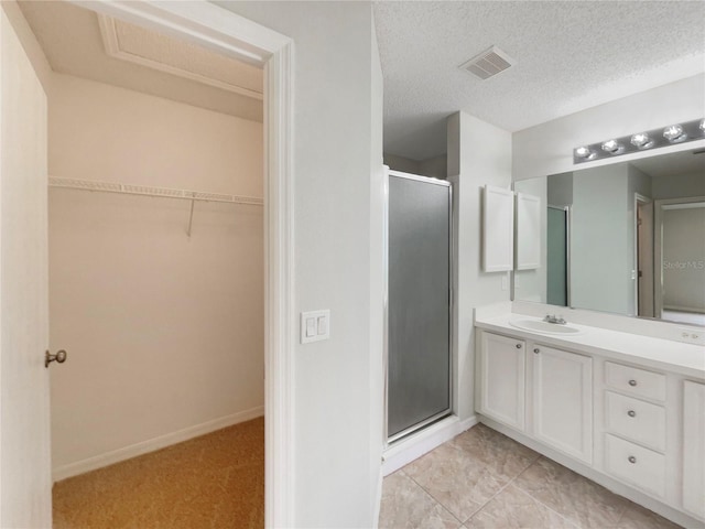 9514 SE 168th Maplesong Ln, The Villages, FL 32162 - full bath with a stall shower, vanity, a walk in closet, baseboards, and a textured ceiling
