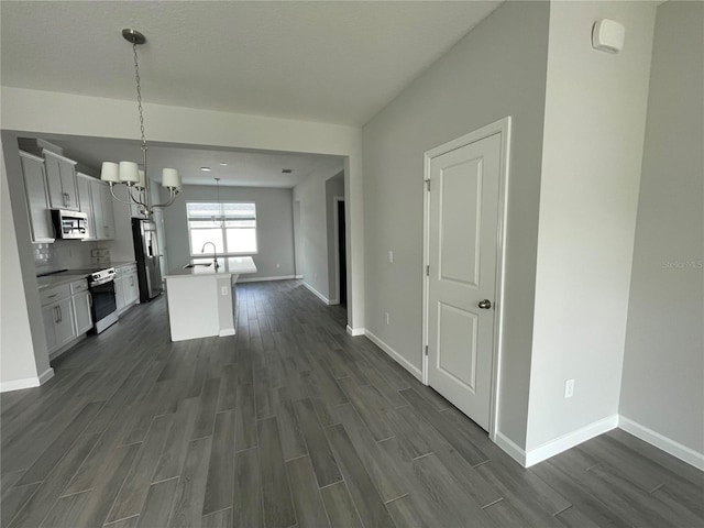 1356 Lumpini St, Saint Cloud, FL 34771 - kitchen with appliances with stainless steel finishes, dark wood-style flooring, a chandelier, and a center island with sink