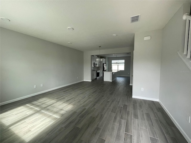 1356 Lumpini St, Saint Cloud, FL 34771 - unfurnished living room with dark wood-style flooring and baseboards