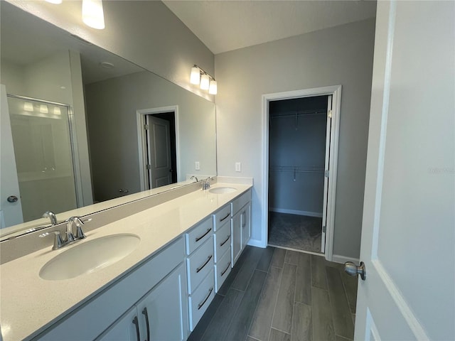 1356 Lumpini St, Saint Cloud, FL 34771 - bathroom with wood finish floors, double vanity, a shower with door, and a spacious closet