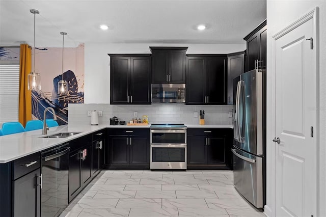 4161 Paragraph Dr, Kissimmee, FL 34746 - kitchen with stainless steel appliances, a sink, dark cabinetry, light marble finish flooring, and a peninsula