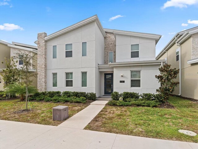 4161 Paragraph Dr, Kissimmee, FL 34746 - view of front of house featuring stucco siding, stone siding, and a front lawn