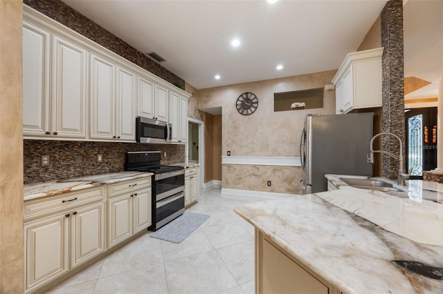 1874 Royal Majesty Ct, Oviedo, FL 32765 - kitchen with appliances with stainless steel finishes, a sink, light stone countertops, cream cabinets, and recessed lighting