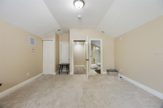 1874 Royal Majesty Ct, Oviedo, FL 32765 - unfurnished bedroom with light carpet, lofted ceiling, connected bathroom, a closet, and baseboards
