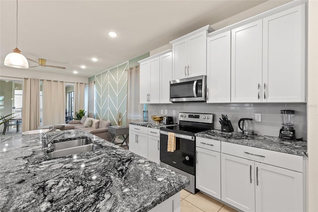 1809 Tropical Palms Cir, Kissimmee, FL 34747 - kitchen featuring stainless steel appliances, white cabinetry, tasteful backsplash, and recessed lighting