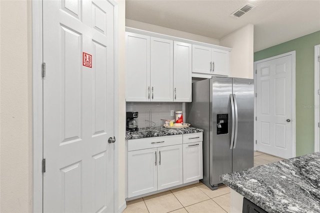 1809 Tropical Palms Cir, Kissimmee, FL 34747 - kitchen featuring stainless steel refrigerator with ice dispenser, light tile patterned flooring, dark stone counters, white cabinetry, and backsplash
