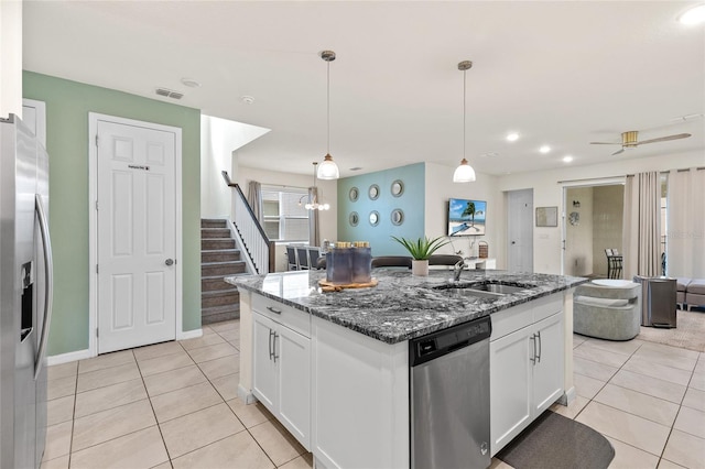 1809 Tropical Palms Cir, Kissimmee, FL 34747 - kitchen featuring stainless steel appliances, light tile patterned flooring, white cabinetry, dark stone counters, and a kitchen island with sink