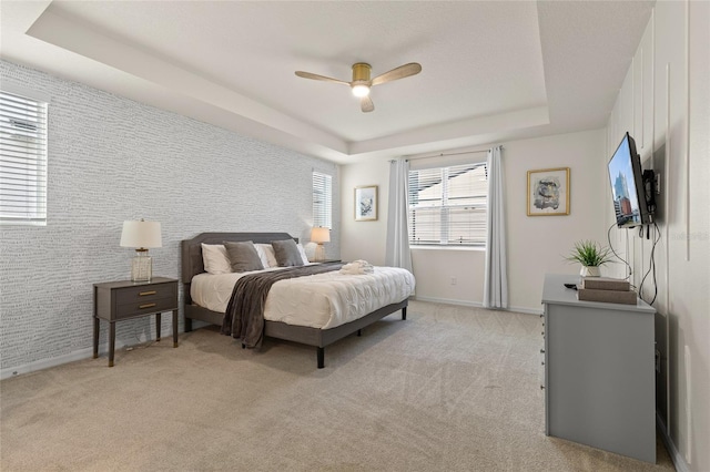 1809 Tropical Palms Cir, Kissimmee, FL 34747 - bedroom with a raised ceiling, light colored carpet, an accent wall, and a ceiling fan