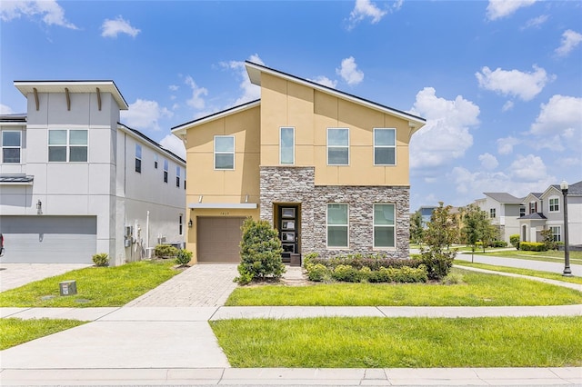 1809 Tropical Palms Cir, Kissimmee, FL 34747 - contemporary home featuring stucco siding, stone siding, a garage, decorative driveway, and a residential view