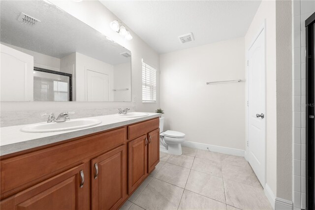 236 Miles Ct, Davenport, FL 33837 - bathroom with double vanity, toilet, an enclosed shower, tile patterned flooring, and baseboards