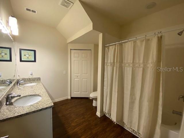 5370 Diplomat Ct Unit 107, Kissimmee, FL 34746 - bathroom featuring double vanity, wood finished floors, toilet, shower / bath combination with curtain, and baseboards