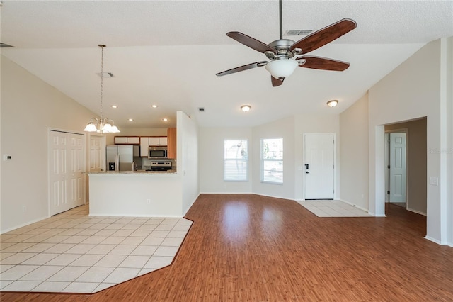 11212 3rd Ave E, Bradenton, FL 34212 - unfurnished living room featuring light wood-style floors, a ceiling fan, a chandelier, high vaulted ceiling, and baseboards